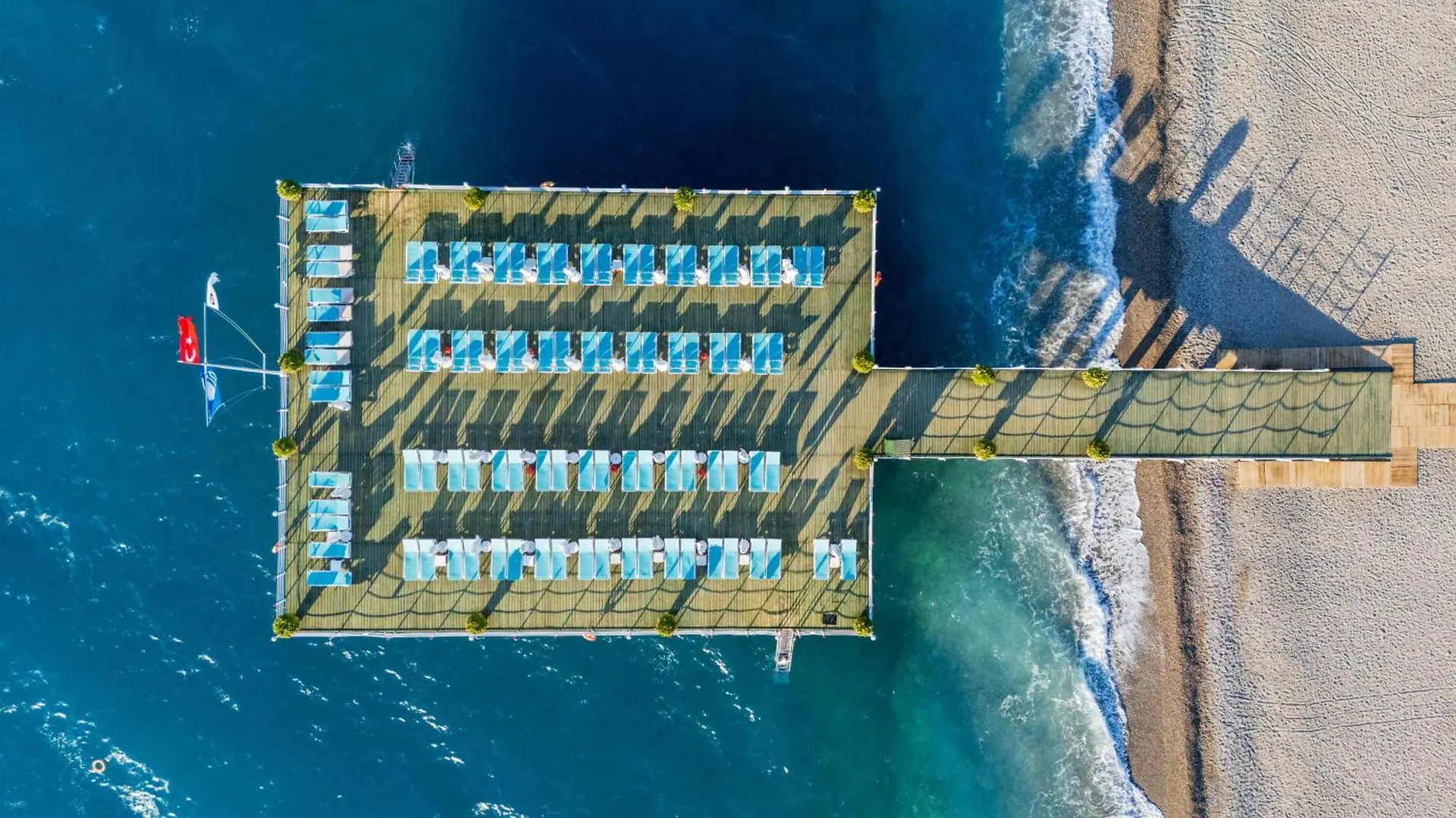 Limak Limra Hotel & Resort Kemer - Kids Concept Exterior photo The photo is an aerial view of a resort or hotel area situated right on a beautiful beach. The main focus is a large, rectangular structure extending out into the turquoise water. This structure appears to be a pier or a large platform with numerous 